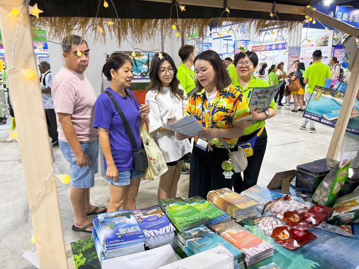 工作人员向马来西亚市民游客介绍海南旅游资源。